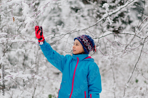 Girl standing in a wintry forest photo