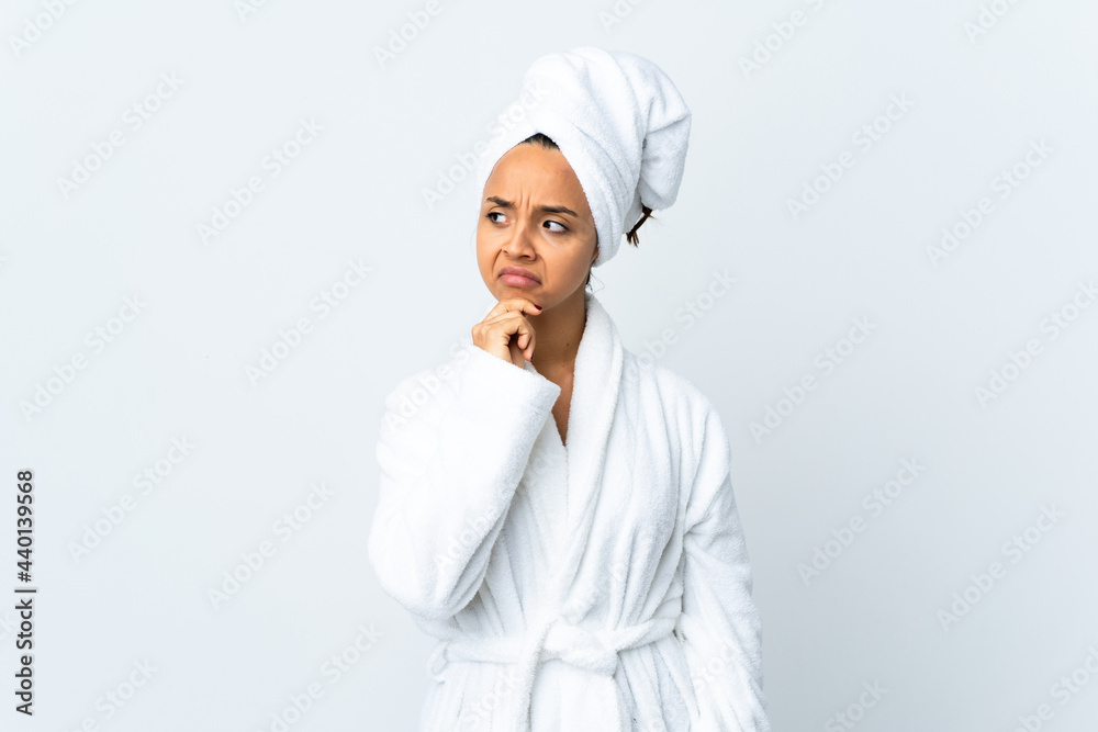 Young woman in bathrobe over isolated white background having doubts and thinking Young woman in bathrobe over isolated white background having doubts and thinking