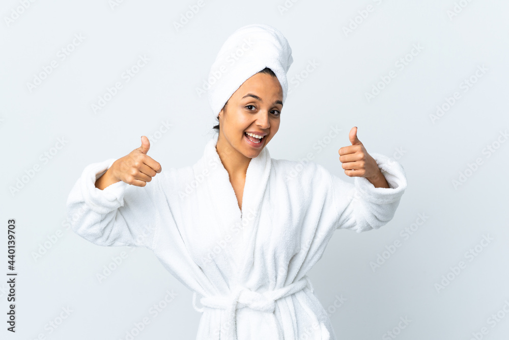 Young woman in bathrobe over isolated white background giving a thumbs up gesture Young woman in bathrobe over isolated white background giving a thumbs up gesture
