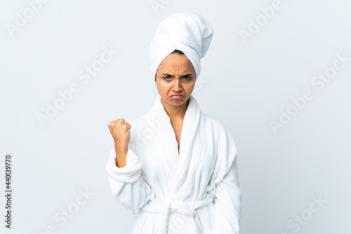Young woman in bathrobe over isolated white background with unhappy expression
