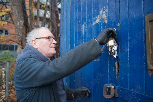 Caucasian male technician with keys opening door of workshop