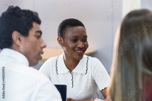 Smiling businesswoman in meeting with colleagues at workplace photo