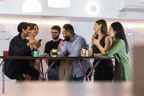 Male and female coworkers talking while taking break at office