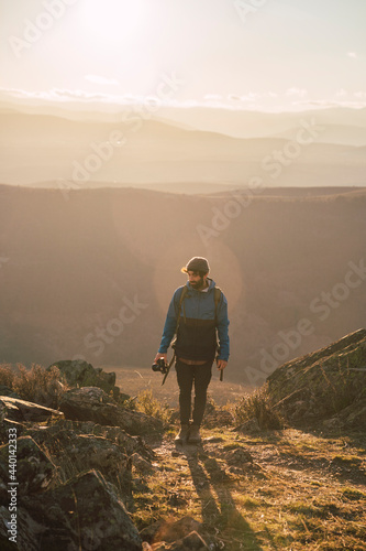 Male hiker standing on mountain path photo