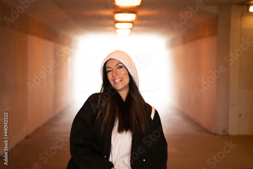 Beautiful woman wearing hooded jacket standing in underground photo