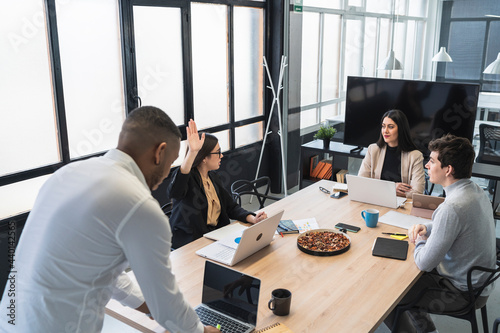 Multi ethnic male and female entrepreneurs discussing during meeting in coworking office