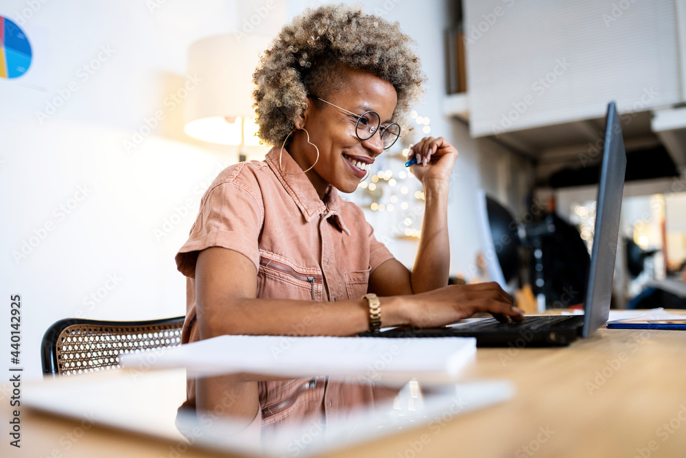 © Rafael Fernandez Torres/Westend61 - Smiling female professional using laptop while working at home office © Rafael Fernandez Torres/Westend61 - Smiling female professional using laptop while working at home office