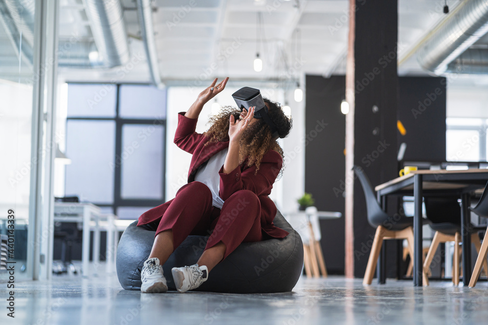 © SERGIO NIEVAS/Westend61 - Businesswoman gesturing while using virtual reality simulator in office