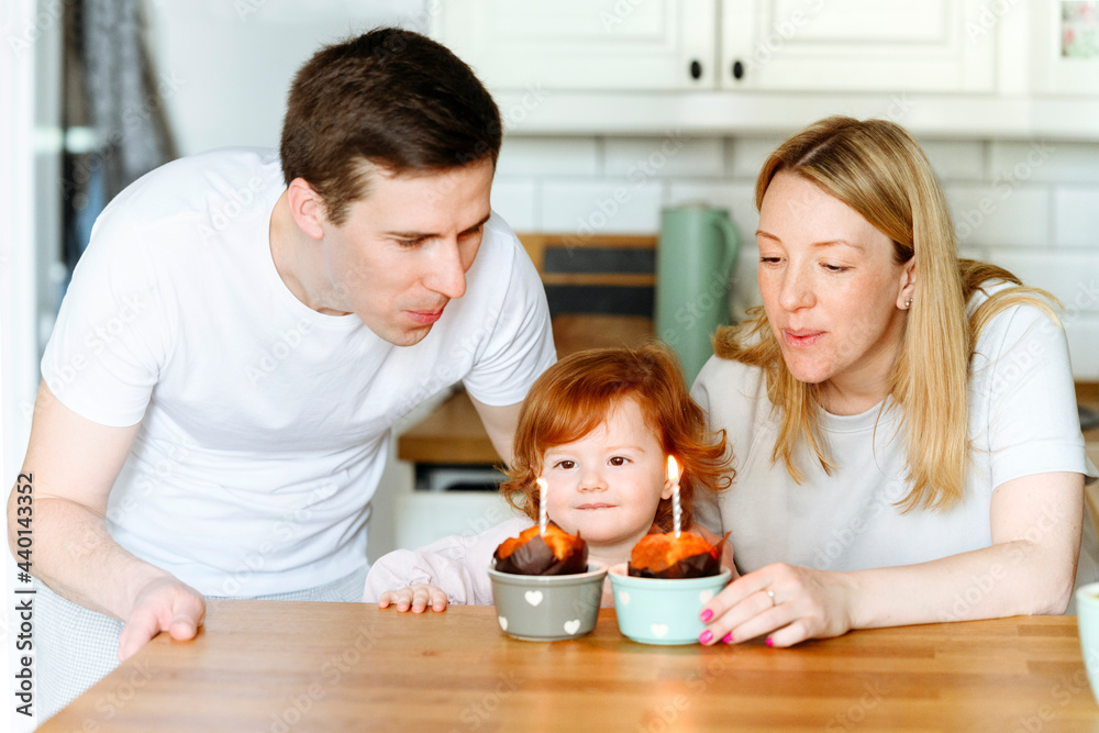 Girl looking at candles amidst parents in kitchen Girl looking at candles amidst parents in kitchen
