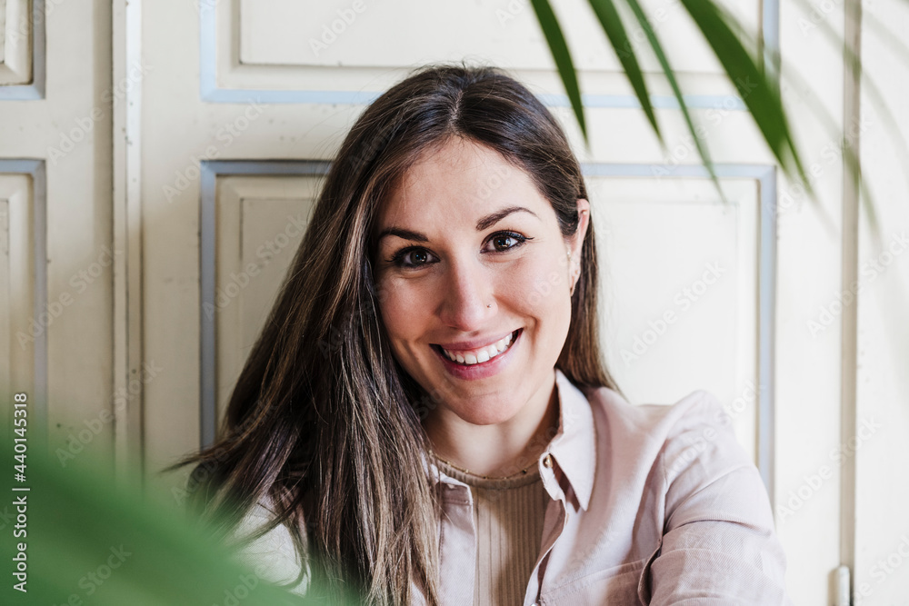 Smiling beautiful woman in front of wall at home Smiling beautiful woman in front of wall at home