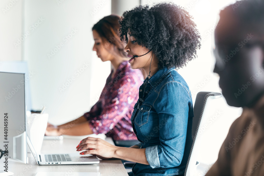 © JOSEP SURIA/Westend61 - Female customer service representative using laptop while sitting amidst colleagues at office © JOSEP SURIA/Westend61 - Female customer service representative using laptop while sitting amidst colleagues at office