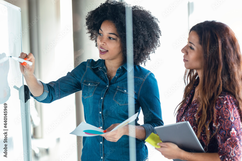 © JOSEP SURIA/Westend61 - Young female professional discussing over white board with female colleague at office © JOSEP SURIA/Westend61 - Young female professional discussing over white board with female colleague at office