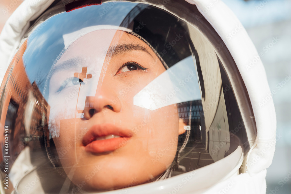 © Eugenio Marongiu/Westend61 - Female astronaut looking away through space helmet during sunny day