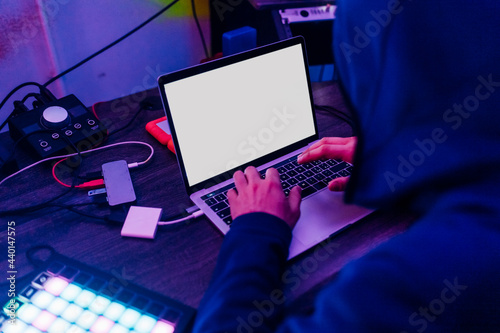 Male data hacker using laptop at home photo