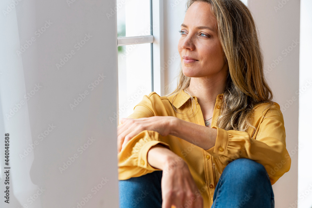 Woman day dreaming while sitting at window Woman day dreaming while sitting at window