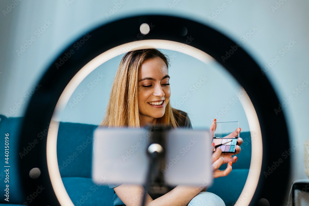 © Xavier Lorenzo/Westend61 - Smiling female influencer with make-up palette vlogging at home © Xavier Lorenzo/Westend61 - Smiling female influencer with make-up palette vlogging at home