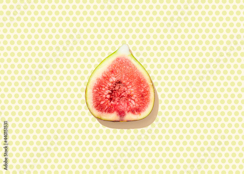 Studio shot of halved fig lying on Polka dot pattern