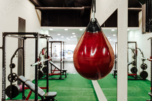 Red punching bag hanging in gym photo