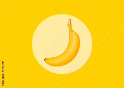 Studio shot of single banana lying against yellow background photo