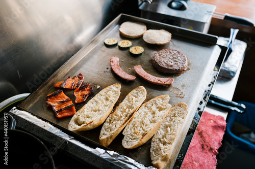 Hamburger ingredients on griddle of restaurant