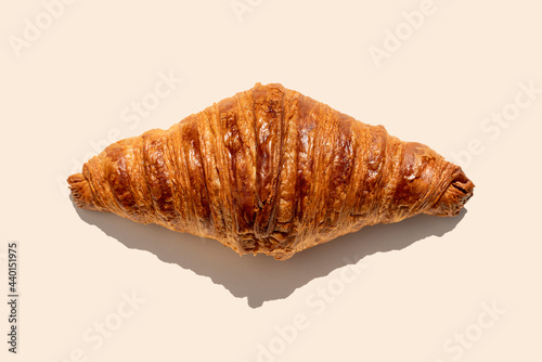Freshly baked butter croissant on biege background