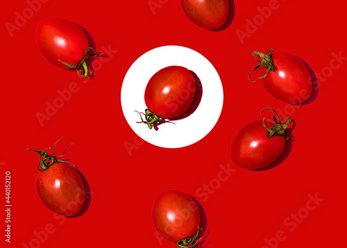 Studio shot of cherry tomatoes lying against red background photo