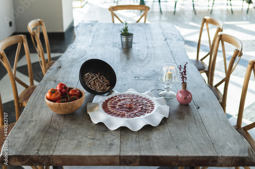 Bowl of tomato by ham slices in plate at restaurant