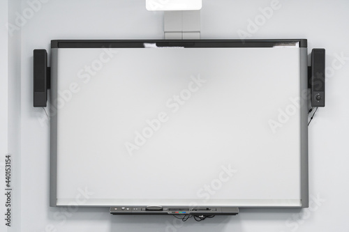 Blank projection screen on white wall in office photo