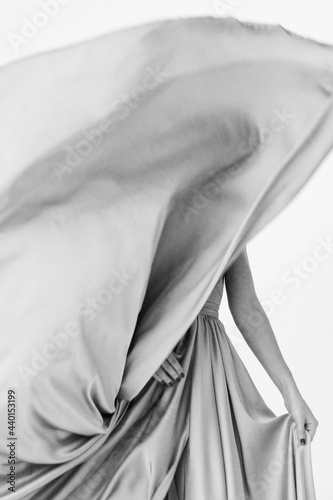 black and white frame. a girl in a wedding dress fluttering in the wind. flying fabric