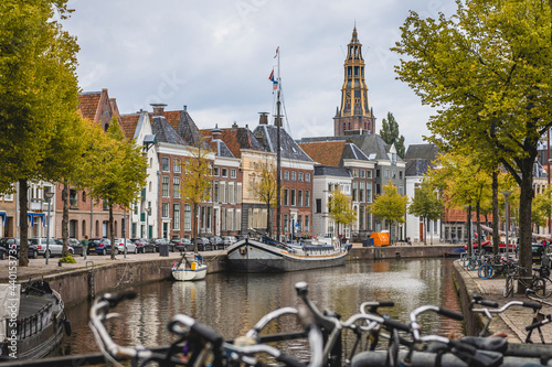 Netherlands, Groningen, City canal with row of townhouses in background photo