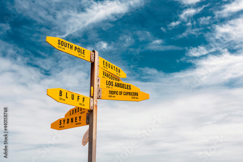 Directional signpost standing against sky