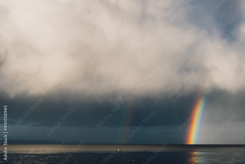 gray clouds with rainbow over the sea ocean 