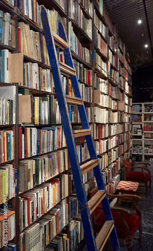 Ladder over bookshelf In library photo