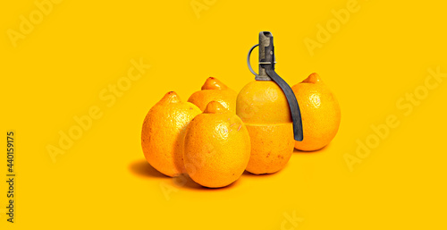 Lemons and grenade against yellow background photo