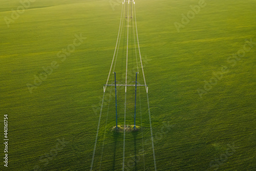 High voltage power line on industrial electricity line tower for electrification rural countryside. Energy transmisson with overhead power line