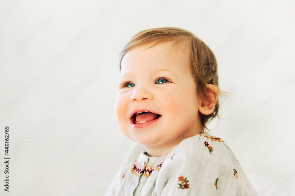 Close up portrait of adorable toddler girl with blue eyes on white background