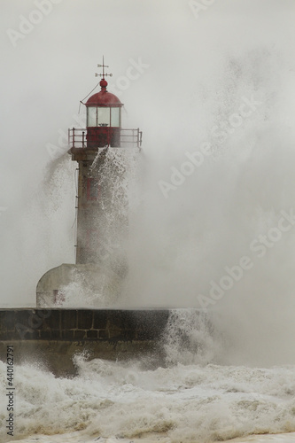 Old lighthouse covered by stormy waves
