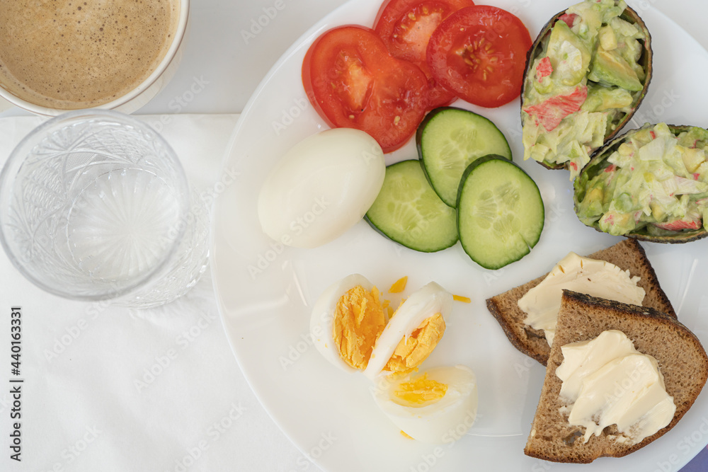 Breakfast on the bed Vegetables tomatoes and cucumbers salad of avocado and eggs. Serving white plate. Proper nutrition Breakfast on the bed Vegetables tomatoes and cucumbers salad of avocado and eggs. Serving white plate. Proper nutrition