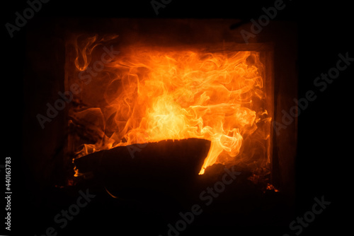 Burning fireplace. Glowing fire logs. Coziness warm christmas time.