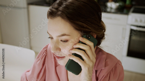 An adult woman is talking on phone and looking through documents photo