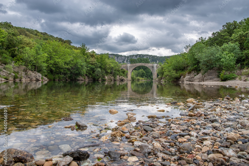 View of the river Herault in the South of France with the bridge of Saint Etienne d'Issensac in the background View of the river Herault in the South of France with the bridge of Saint Etienne d'Issensac in the background