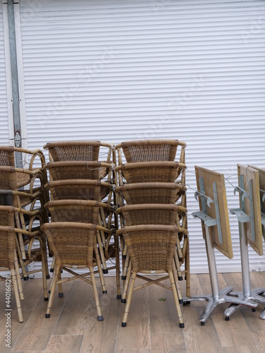 Some chairs stacked in front of a closed cafe. Le Pouliguen, France, june 2021.