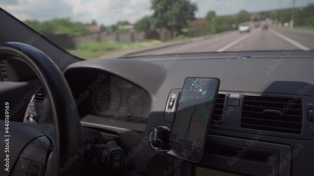 Car dashboard with smartphone used as navigation device. Urban driving lifestyle with mobile app technology. Smartphone in a car use for Navigate or GPS. Driving a car with smartphone in holder.