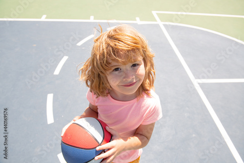 Portrait of a cute child boy play basketball. Funny kids face. © Volodymyr