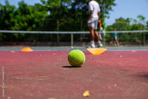 Jugador de tenis en acción en la pista de tenis (enfoque selectivo, foco en el baile en primer plano).