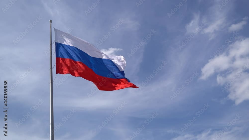 4K shooting. The national flag of Russia flutters in the wind attached to a flagpole with a blue cloudy sky. 4K shooting. The national flag of Russia flutters in the wind attached to a flagpole with a blue cloudy sky.