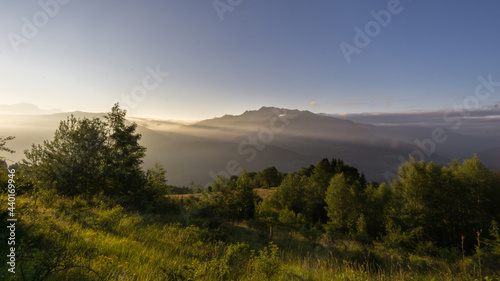 panorama of peaceful morning with sunrise over french alps with meadow in foreground