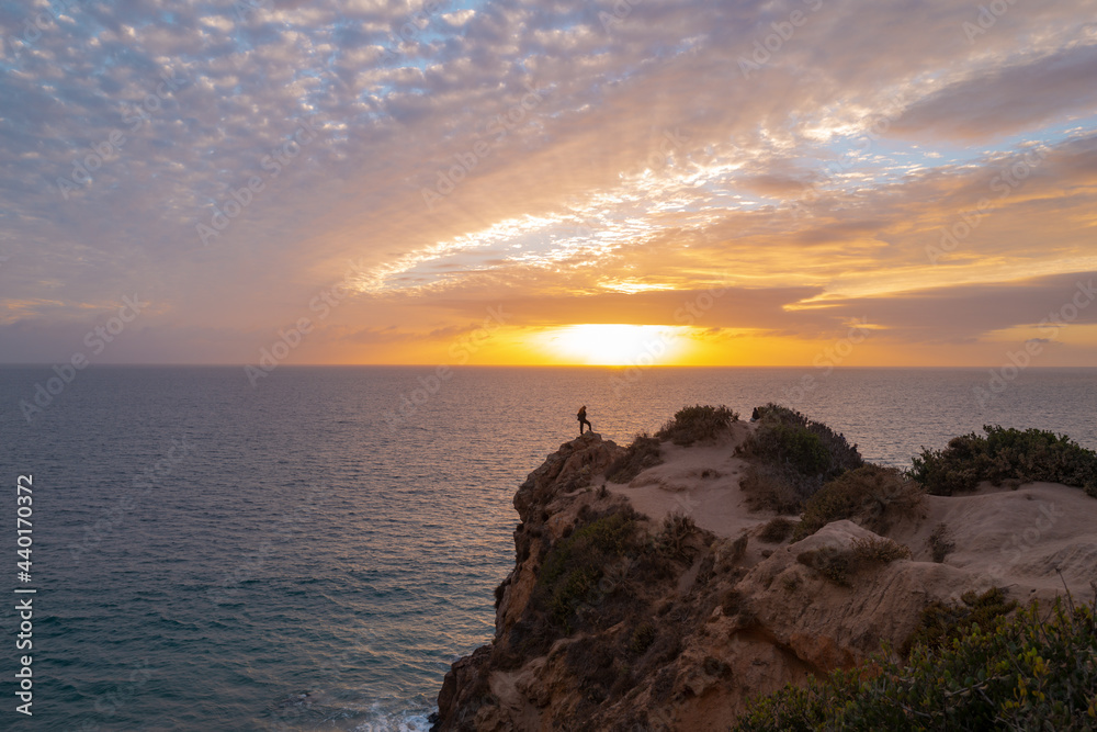 Calm sea and rock with sunset sky and sun through the clouds over. Ocean and sky background, seascape, ibiza.
