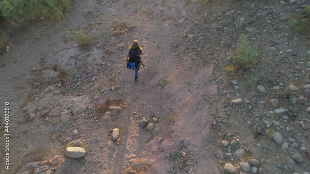 Aerial Drone Hike with Backpacker in Dry and Rocky Desert in the Early Morning Above Aerial Drone Hike with Backpacker in Dry and Rocky Desert in the Early Morning Above