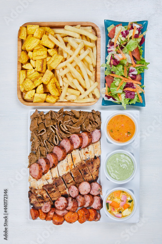 variety of grilled meats with salad and french fries